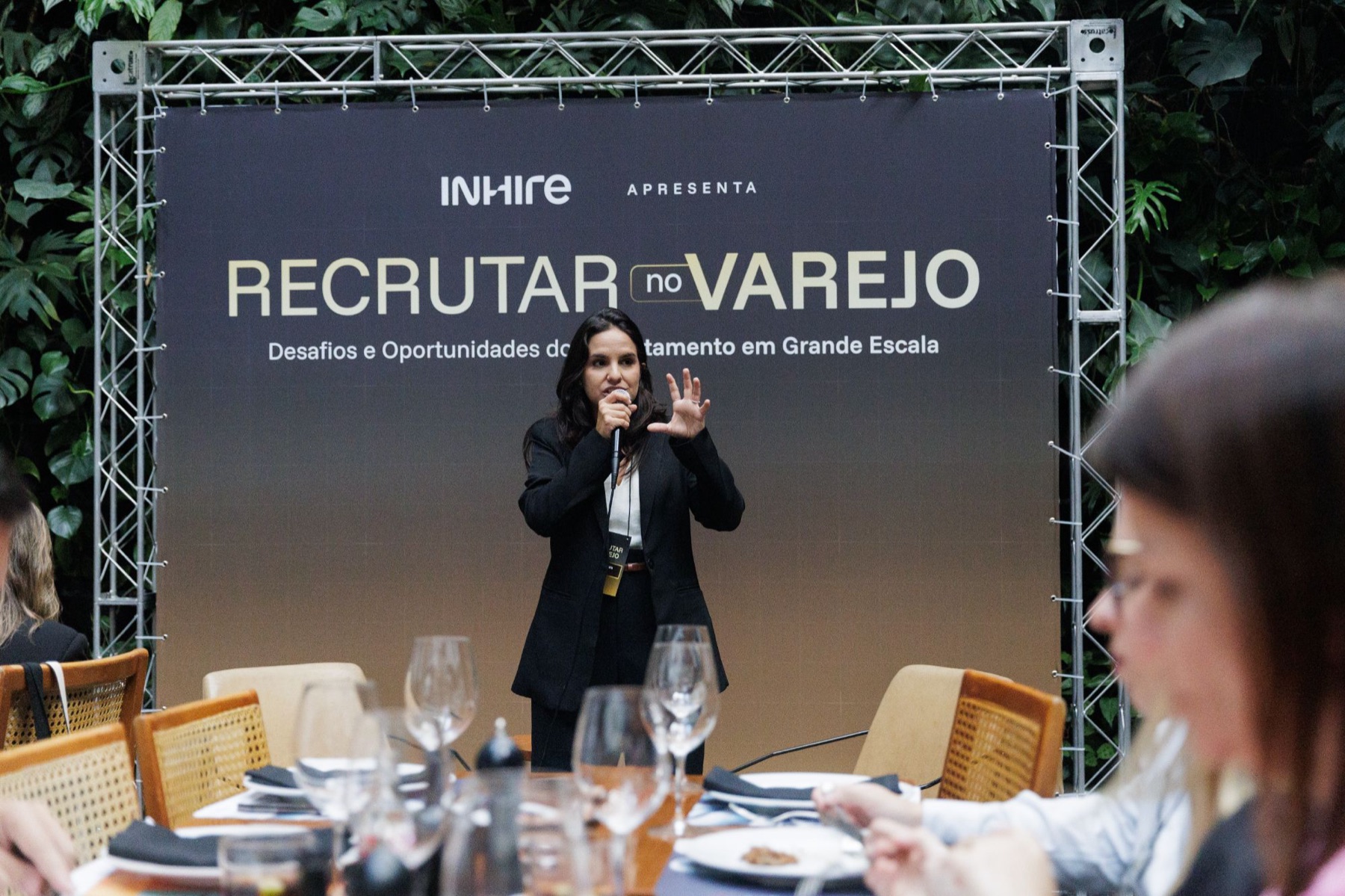 Palestrante falando em frente ao painel do Recrutar no Varejo